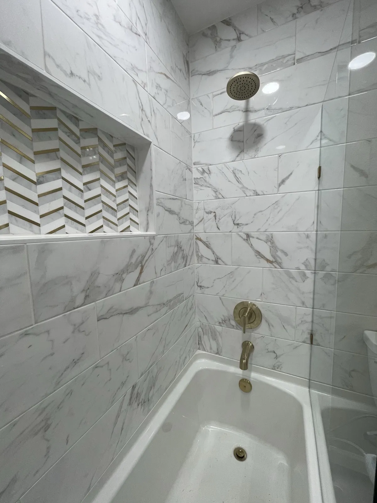 After: shower niche and gold fixtures closeup