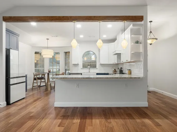 After: kitchen peninsula with wood beam and pendant lights