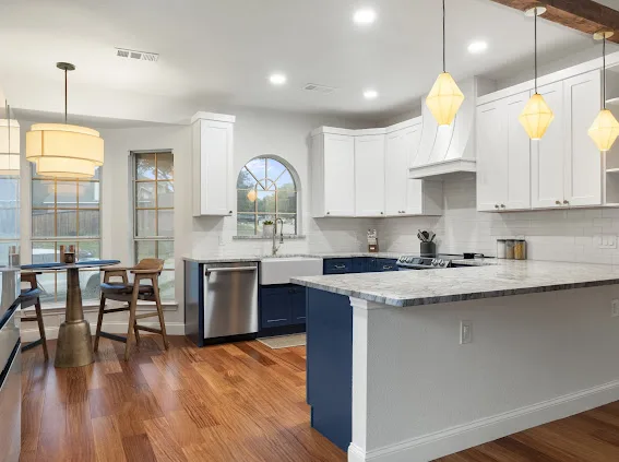 After: white upper cabinets, navy lowers and farmhouse sink